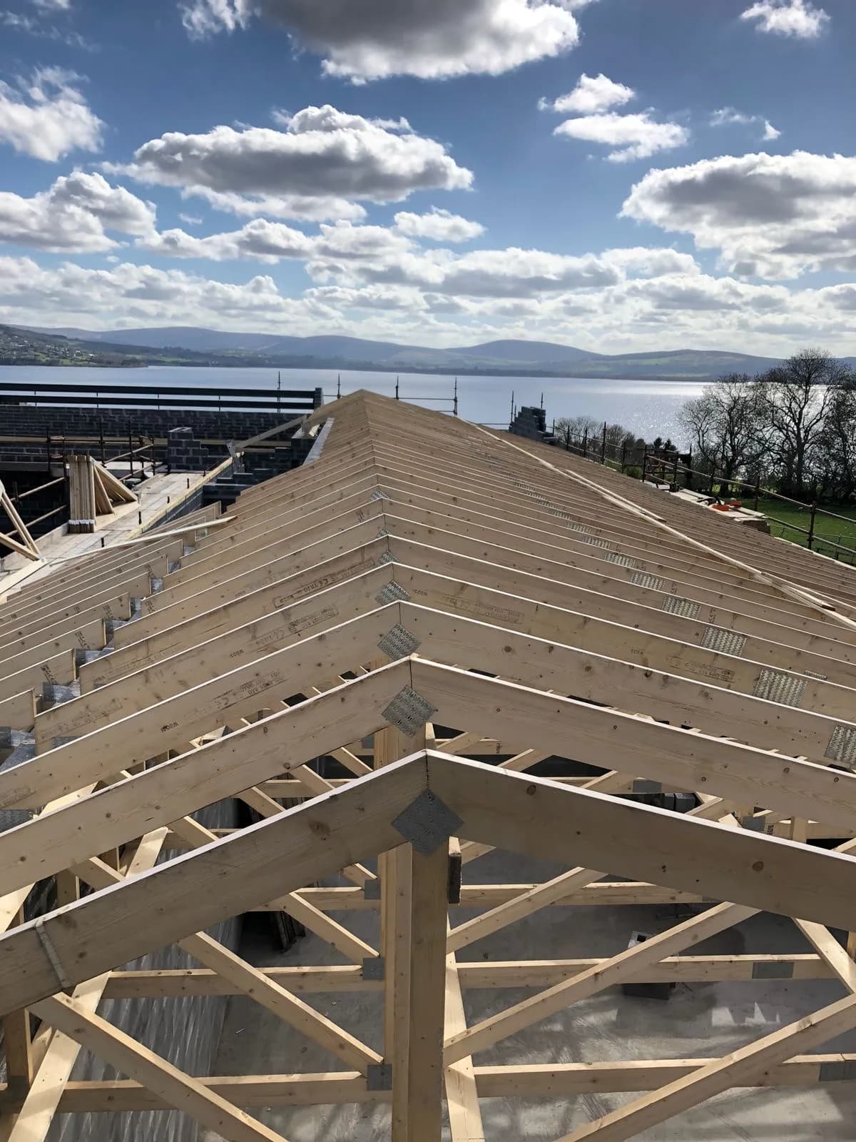 New timber roof structure under construction with a scenic backdrop