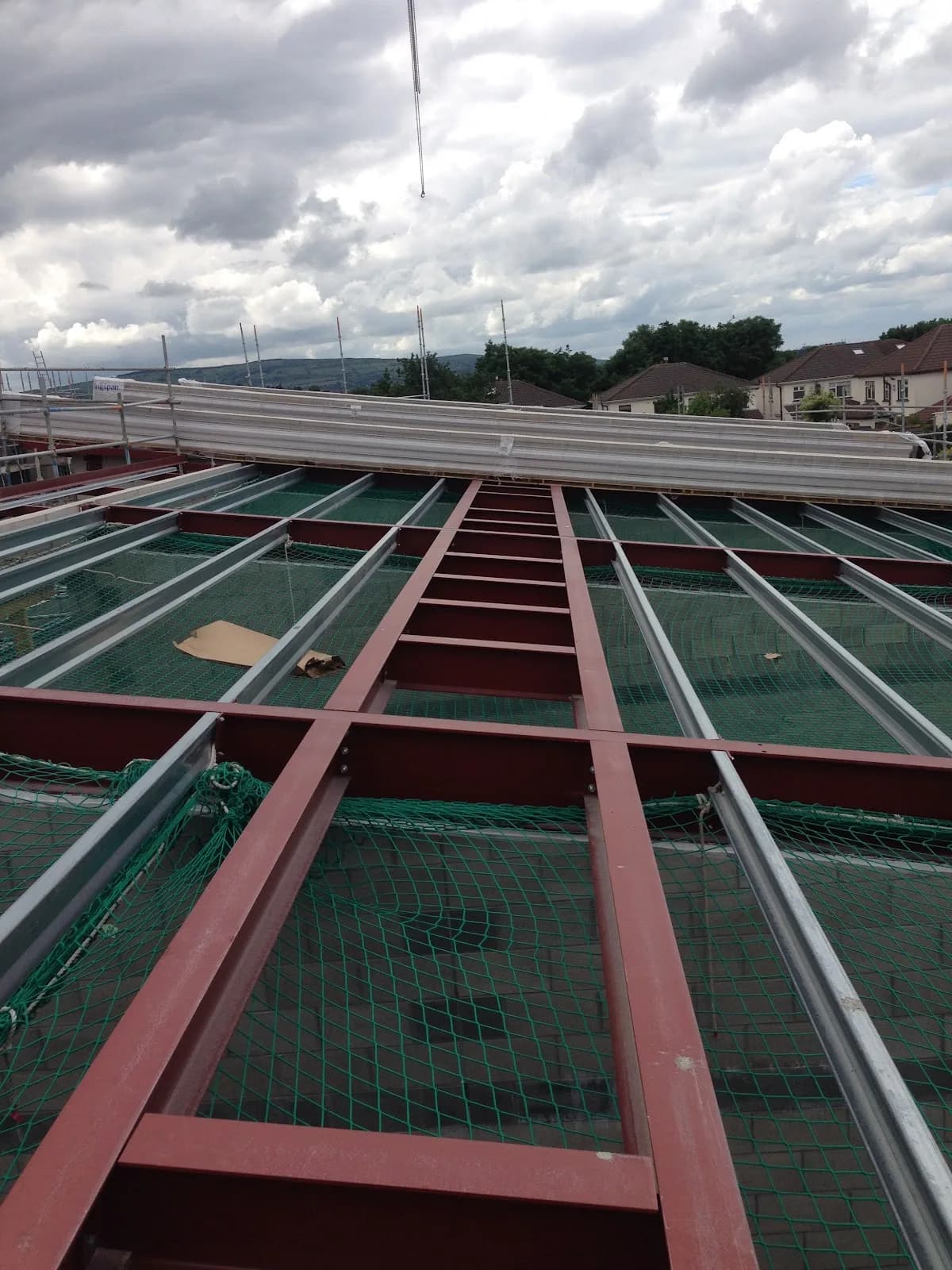 Structural steelwork and safety netting on a roofing project in progress